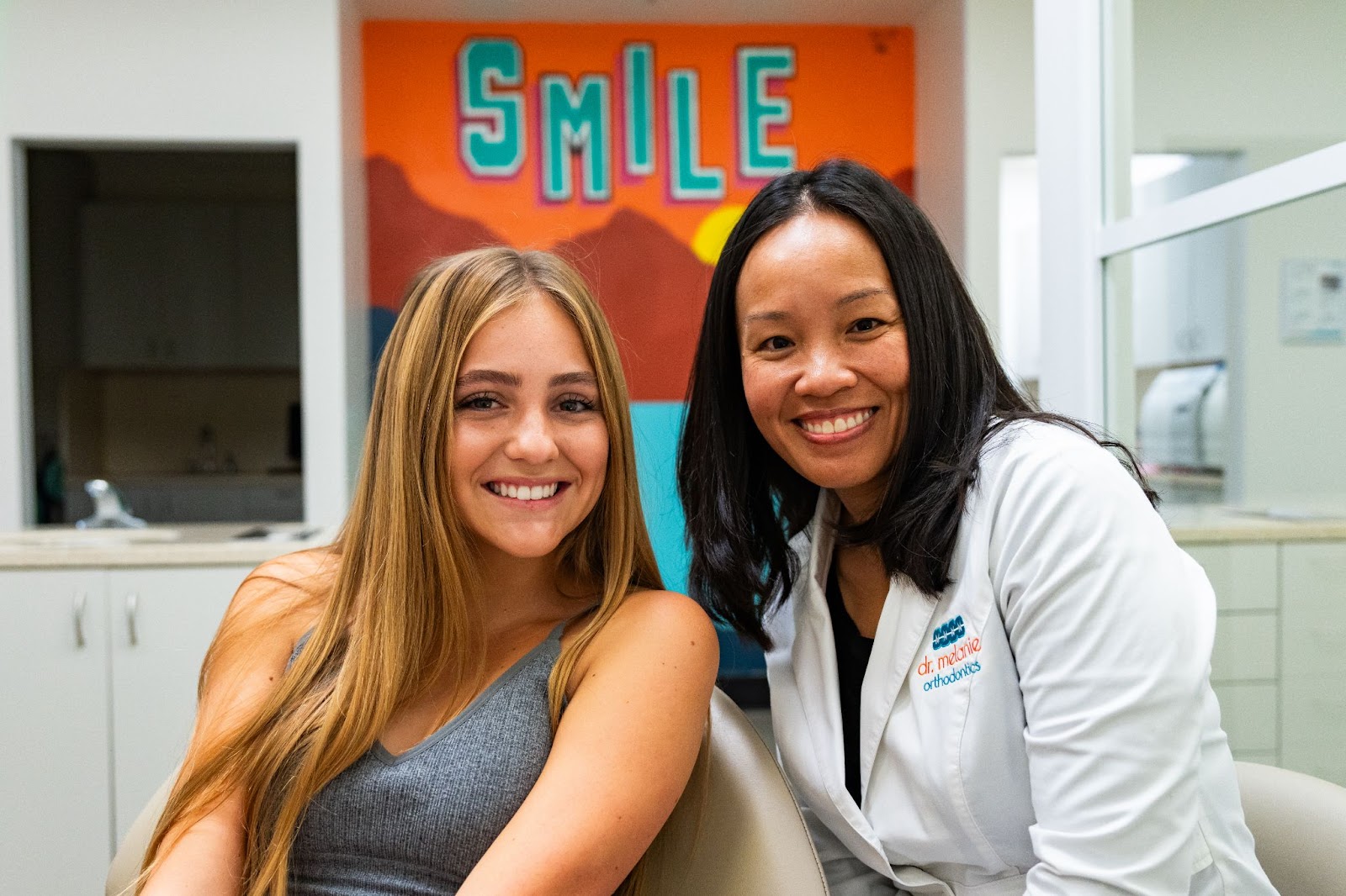 Smiling patient and orthodontist in clinic setting, promoting healthy smiles and orthodontic care at Dr. Melanie Orthodontics.